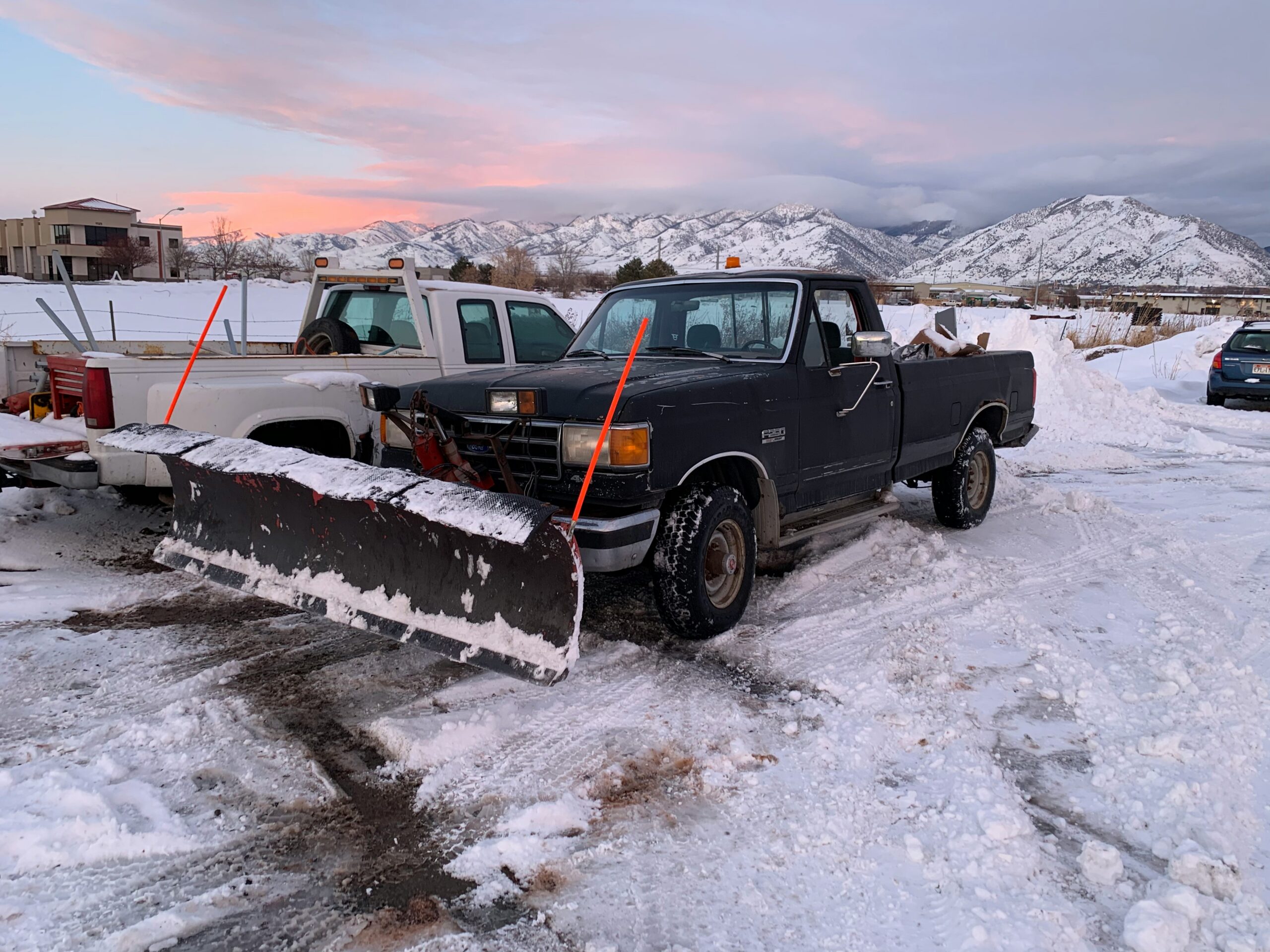 A black truck secured with orange straps, showcasing its cargo and sturdy design.